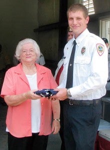 Rebecca Godwin, secretary of WoodmenLife Chapter 862, presents Woodland Fire Chief Greg Canady with the new flag.