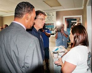 Gov. McCrory chats with Heather Lawicki, an employee of Hammerheads Oyster Bar, a business on Windsor’s King Street that was heavily damaged by the flooding. At left is local District 5 State House Representative Howard Hunter III.